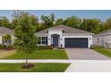 Charming single-Gathering home features a well-manicured lawn, gray door, and two-car garage at 9033 Cape Cod Rd, Deland, FL 32724