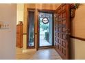Welcoming entryway featuring an open door, wood floors, and an adjacent decorative wall with a lovely wreath at 929 Torchwood Dr, Deland, FL 32724