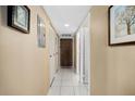 Hallway featuring white tile flooring, neutral walls and access to storage and additional rooms at 935 N Halifax Ave # 309, Daytona Beach, FL 32118