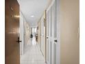 Bright hallway with white tile flooring leads to a dining area, featuring plenty of storage at 935 N Halifax Ave # 309, Daytona Beach, FL 32118