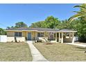 Inviting single-story home featuring a manicured lawn and convenient covered parking at 10 Lilac Dr, Debary, FL 32713