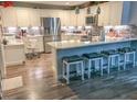 Spacious kitchen with stainless steel appliances, white cabinets, and breakfast bar seating at 1622 Navidad St, The Villages, FL 32162