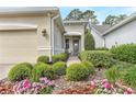 Inviting entrance adorned with lush landscaping and colorful flowers, leading to the charming beige stucco home at 1684 Victoria Gardens Dr, Deland, FL 32724