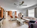 Spacious living room with tile floors and neutral paint flows into the dining area and kitchen at 1711 Francisco St, The Villages, FL 32159