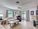 Inviting living room with tile floors, neutral paint, a ceiling fan, and sliding glass doors to the outside at 1711 Francisco St, The Villages, FL 32159