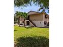 Charming two-story condo with palm trees, well-manicured lawn, and inviting entryway stairs at 190 Hickory Woods Ct # 15C, Deltona, FL 32725