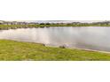 Panoramic view of a serene lake surrounded by lush greenery and neighboring houses in the distance at 207 Pitching Wedge Dr, Daytona Beach, FL 32124