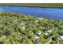 Expansive aerial shot of a lush residential neighborhood with mature trees and a glistening river in the background at 2149 Hontoon Rd, Deland, FL 32720