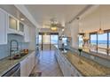 Bright kitchen with white cabinetry, granite countertops, and expansive views of the ocean at 2200 N Atlantic Ave # 1201, Daytona Beach, FL 32118