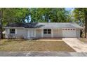 Single-story home features a manicured lawn, attached two-car garage and neutral exterior at 2240 Conway Dr, Deltona, FL 32738
