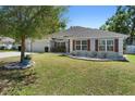 Charming single-story home featuring a well-manicured lawn and a two car garage at 2301 Angel Fish Loop, Leesburg, FL 34748