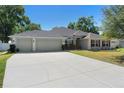 Charming single-story home featuring a well-manicured lawn and a two car garage at 2301 Angel Fish Loop, Leesburg, FL 34748