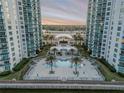 Exterior shot of in-ground pool with lounge chairs and palm trees nestled between two waterfront condo buildings at 241 Riverside Dr # 601, Daytona Beach, FL 32117