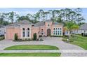 Attractive single-story home featuring a large circular driveway, manicured lawn and a lush tropical landscape at 2454 Hyatt Creek Ln, Port Orange, FL 32128