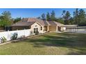 Exterior angle showcasing the fenced yard, well-maintained lawn, and the side of the house and carport at 2530 Leonard Dr, Deltona, FL 32725