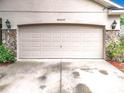 Close up of the home's garage door with stone accents and decorative lighting at 30029 Pga Dr, Sorrento, FL 32776