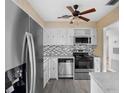 Bright kitchen featuring stainless steel appliances, white cabinets and a ceiling fan at 3005 Garden Rd, Eustis, FL 32726