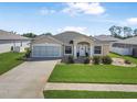 Inviting one story home featuring a well-maintained lawn, charming entrance, and a two-car garage at 307 Mariners Gate Dr, Edgewater, FL 32141