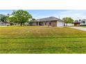 Spacious corner lot home with a brick facade, two car garage, and green lawn at 3104 Umbrella Tree Dr, Edgewater, FL 32141