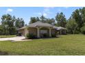 Single-story home with a side-entry garage, green lawn, and mature landscaping at 3211 Hidden Crest Ln, Deland, FL 32724