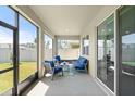 Relaxing screened patio featuring stylish outdoor furniture and a view of the lush backyard at 322 E Merimont Ln, Ormond Beach, FL 32174