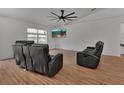 Bright living room featuring wood floors, a ceiling fan, and a mounted TV at 4600 S Tomoka Dr, De Leon Springs, FL 32130