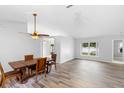 Dining room featuring wood floors, updated lighting, and ample natural light at 484 Sherwood Oaks Rd, Orange City, FL 32763