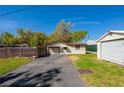Fenced backyard with garage and outbuilding and driveway at 501 Powers Ave, Port Orange, FL 32127