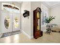 Bright foyer with double doors, tile flooring, and a vintage grandfather clock at 5808 Oak Lake Trl, Oviedo, FL 32765