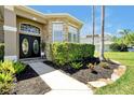 Inviting front entrance with stone accents, manicured shrubs, and decorative double doors at 5808 Oak Lake Trl, Oviedo, FL 32765