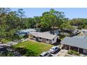 An aerial view of the single-story home with a well-maintained lawn and lush surrounding trees at 614 Johnson Dr, Ormond Beach, FL 32174