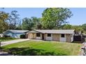 Charming single-story home featuring stone accents, a covered porch, and a well-manicured lawn at 614 Johnson Dr, Ormond Beach, FL 32174