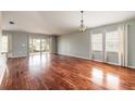 Bright living room featuring wood floors, a sliding glass door, and large windows at 6794 Calistoga Cir, Port Orange, FL 32128