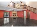Spacious living room features a stone fireplace, tile flooring, and statement chandelier at 7 Appaloosa Trl, Ormond Beach, FL 32174