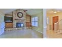 Inviting living room with stone fireplace, tile flooring, and natural light at 1 Fox Hollow Dr, Ormond Beach, FL 32174