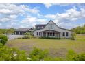 Charming home exterior with a well-manicured lawn, covered porch, and three car garage at 125 Smyrna Dr, Debary, FL 32713