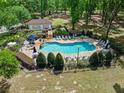 Community pool and lounging area surrounded by lush landscaping and mature trees at 1253 Bramley Ln, Deland, FL 32720