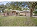 Inviting one-story home with well-maintained landscaping, mature shade tree, and attached two-car garage at 1439 Bent Oaks Blvd, Deland, FL 32724
