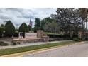 Oakhurst community entrance sign with stone accents, flag, landscaping, and brick-paved entrance drive at 1933 Oak Estates Dr, Orange City, FL 32763
