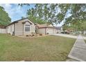 Beautiful single-story home with a three-car garage, landscaped yard, and charming curb appeal at 1933 Oak Estates Dr, Orange City, FL 32763