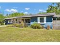 Cozy home with a covered porch, blue siding, white trim, and lovely landscaping at 1941 Jungle Rd, New Smyrna Beach, FL 32168