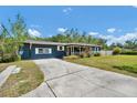 Inviting home with a driveway, grassy lawn, blue siding and a charming covered front porch at 1941 Jungle Rd, New Smyrna Beach, FL 32168