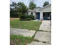 Charming home with a well-maintained lawn and a blue front door at 209 Meghan Cir, Deland, FL 32724