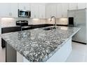 Close up of the kitchen island, with beautiful black-veined granite countertops and modern finishes at 234 Mosaic Blvd, Daytona Beach, FL 32124