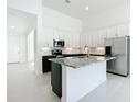 Bright kitchen featuring stainless steel appliances, granite countertops, and sleek white cabinetry at 234 Mosaic Blvd, Daytona Beach, FL 32124