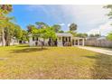 Inviting single-story home featuring lush green lawn, mature trees, and convenient covered parking at 2605 Fairmont Ave, New Smyrna Beach, FL 32168