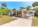 Attractive single-level home boasting colorful landscaping, a convenient carport, and a welcoming entrance at 2605 Fairmont Ave, New Smyrna Beach, FL 32168