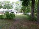 Spacious front yard of home with large, mature trees providing ample shade and privacy at 26225 Troon Ave, Mount Plymouth, FL 32776