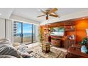 Comfortable living room featuring balcony access, a ceiling fan, and custom built-ins at 2900 N Atlantic Ave # 2003, Daytona Beach, FL 32118