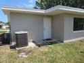 Back exterior of the home with a door, AC unit, and window at 2936 Lantern Dr, South Daytona, FL 32119